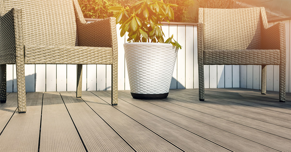 Trex decking prices in 2022 on a deck with two plastic chairs and a plant