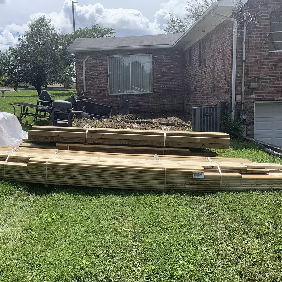 View of back of the house without weeds and decking materials brought in