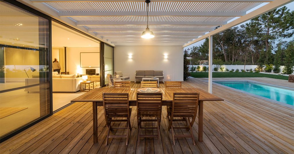 A wood deck near a pool at night