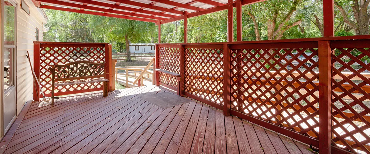 new lattice design railing and wooden deck covered by a pergola
