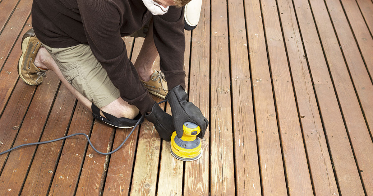 A man sanding a deck with a pro tool