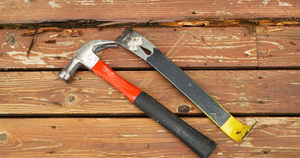 A hammer and a prybar used for deck repairing projects