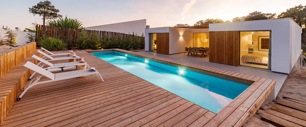 A deck pool with cedar wood and long chairs