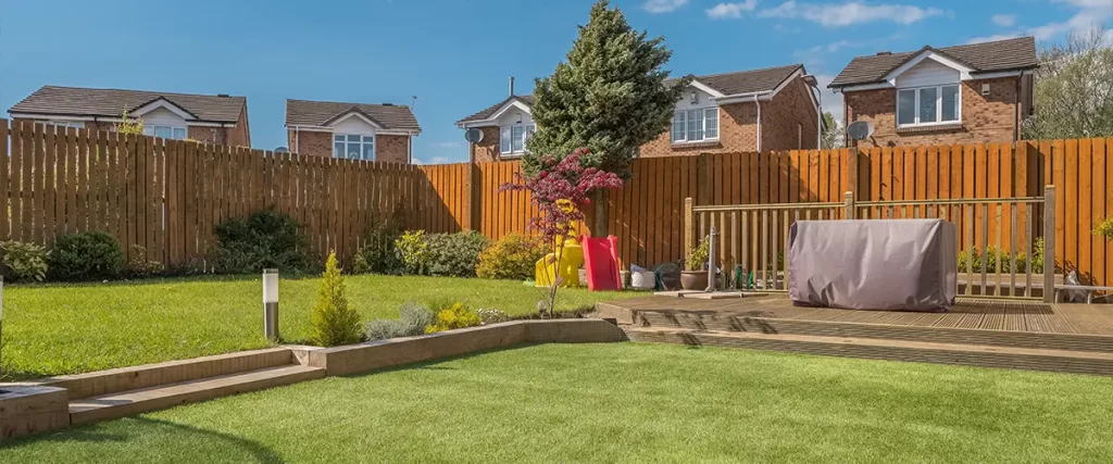 A freestanding deck in a backyard with lawn