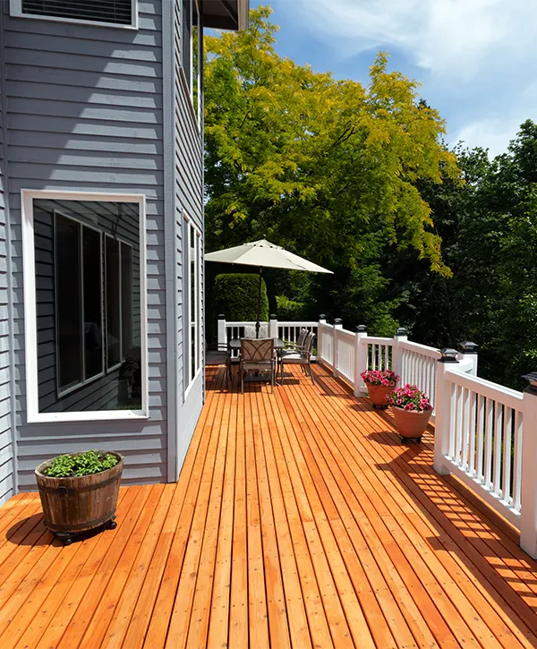 Cedar decking with white railings on a home with gray siding