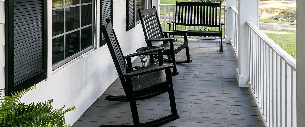 Composite front porch decking with black chairs and white railings