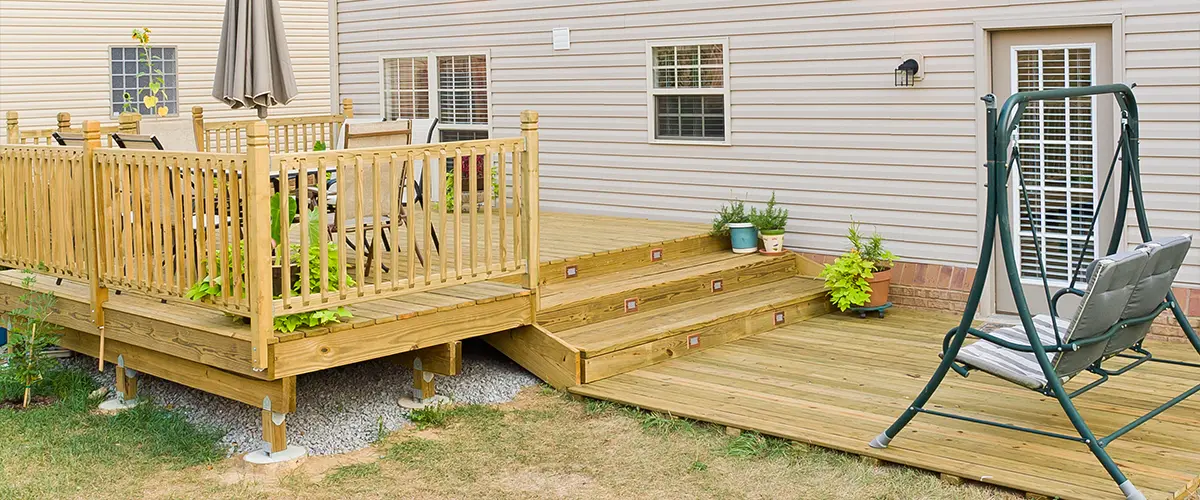 A ground-level wood deck with railing and stair lights
