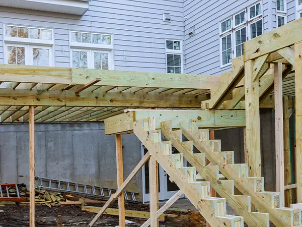 An elevated deck frame made of wood with two sets of stairs