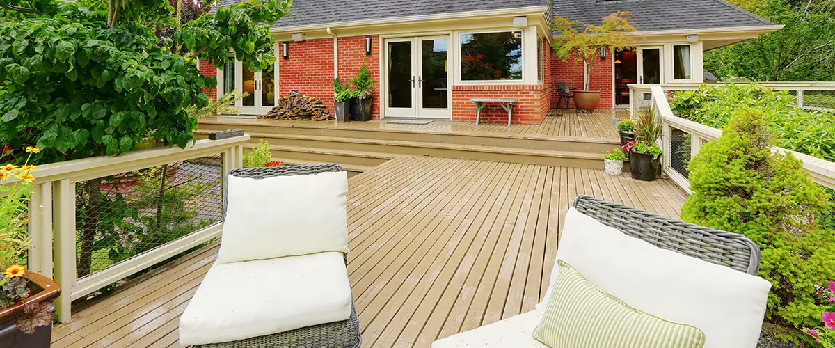 Composite beige decking on a large outdoor space with two white chairs