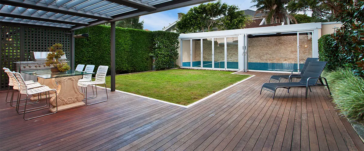 A ground level wood decking with a pergola