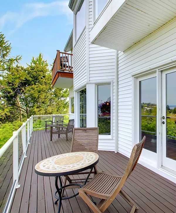 Composite decking with white railing and a round table