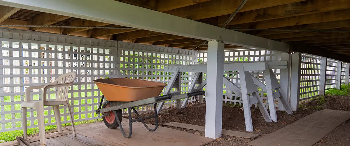 Under deck ceiling with lattice fence and a wheel barrel
