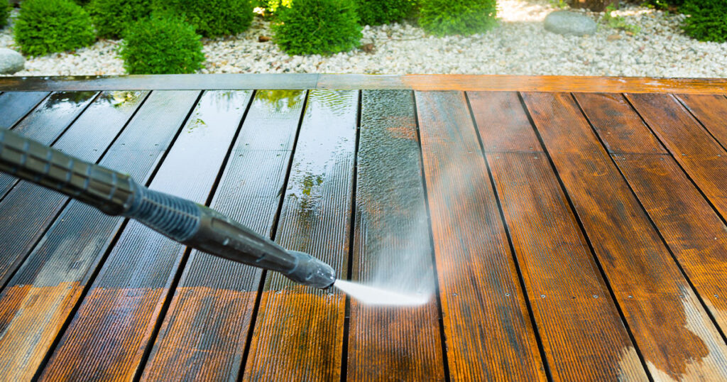 deck cleaning terrace with a power washer - high water pressure cleaner on wooden terrace surface