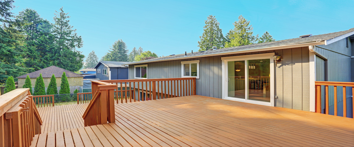 Empty upper level deck boasts redwood railings overlooking the lower level deck.