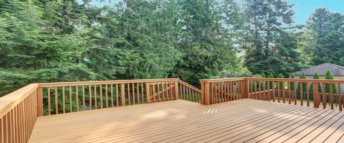 Empty upper level deck boasts redwood railings overlooking the lower level deck.