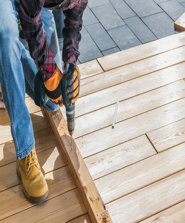 Construction Job. Men Drill Holes Inside Wood Planks. Small House Woodwork. Close Up Photo.