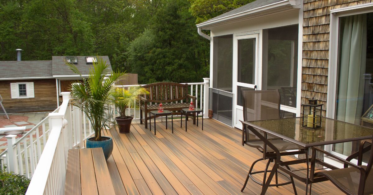 Spacious wooden deck with seating and a screened-in porch