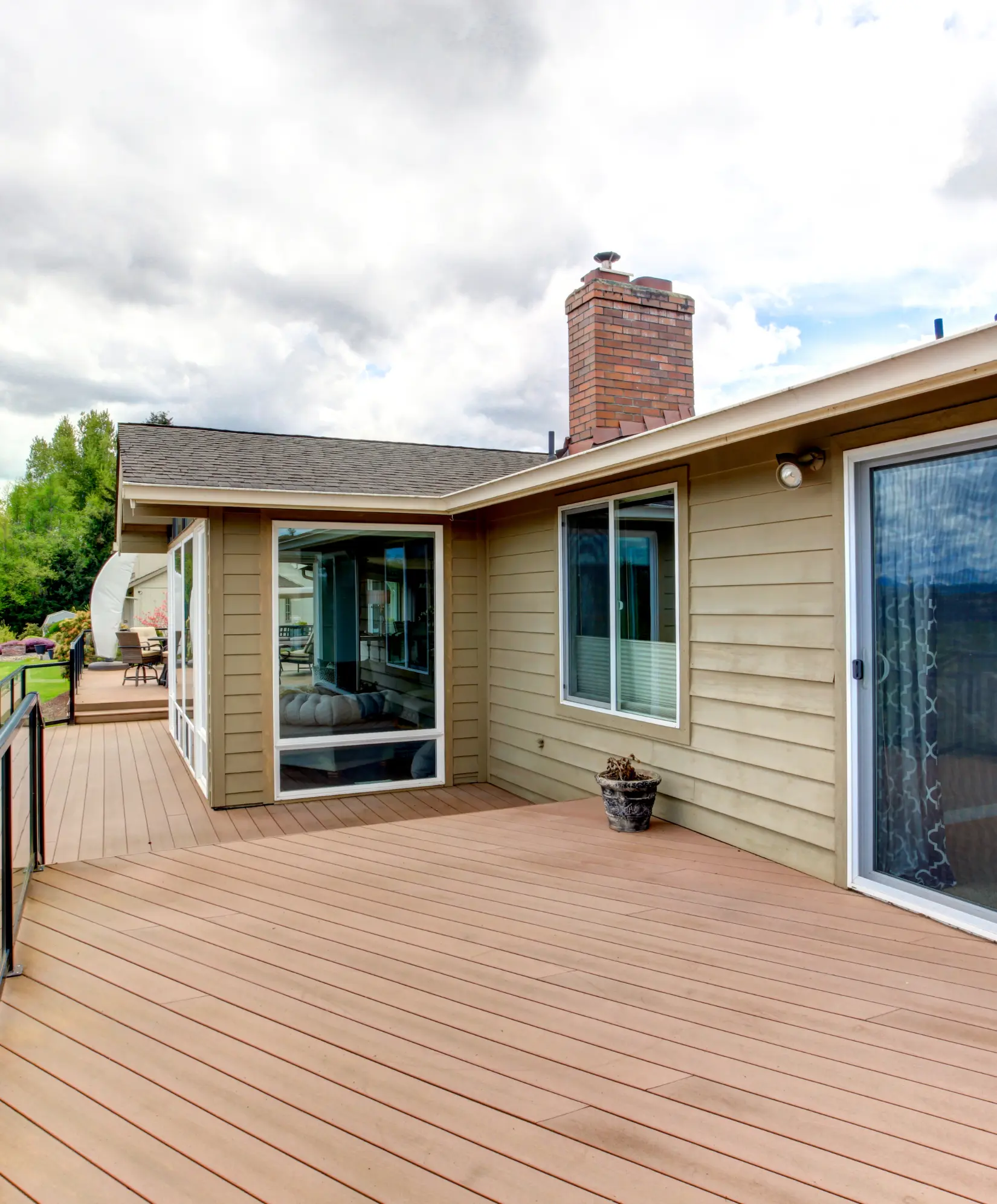 Luxury wood deck with outdoor dining area offering stunning ocean views at sunset