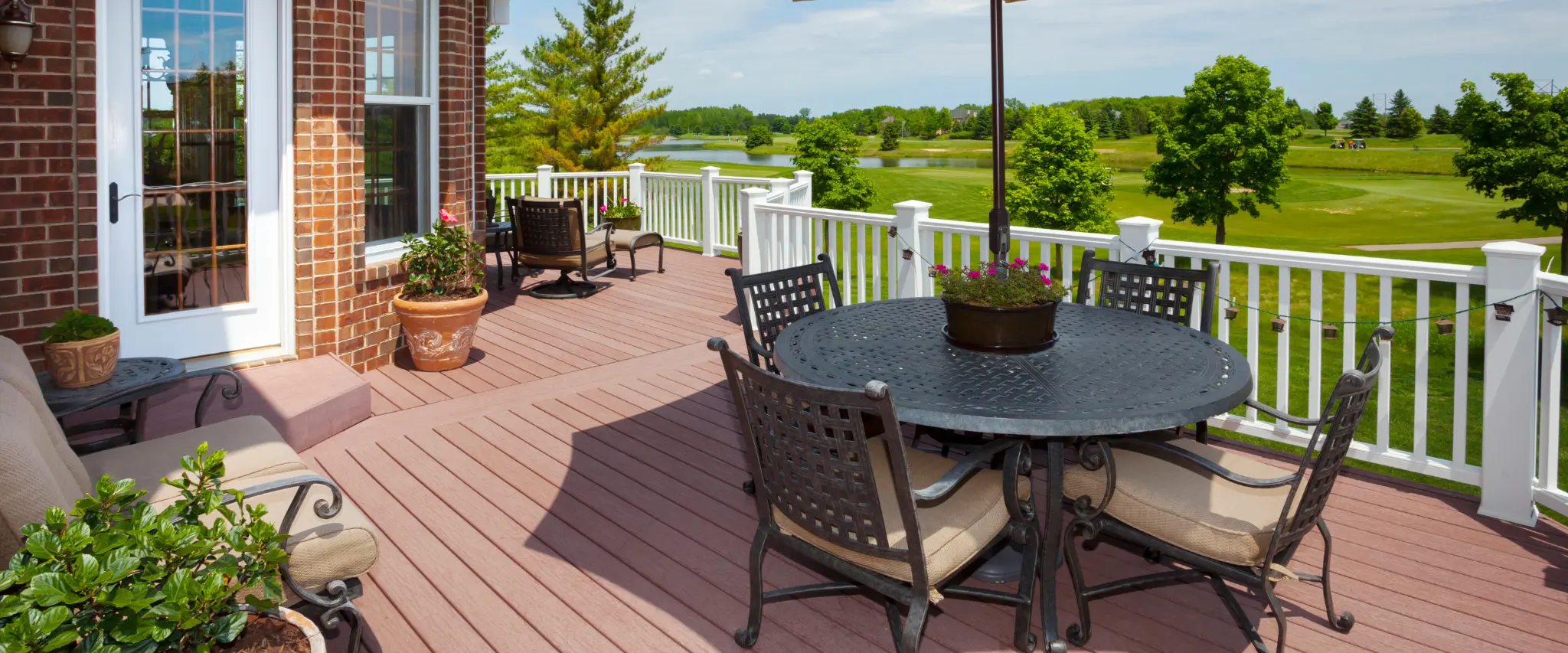 Modern lakeside deck with outdoor furniture and scenic view