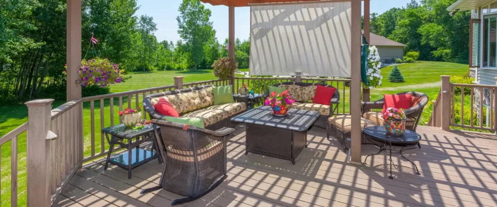 Outdoor deck with a pergola, seating area, and greenery