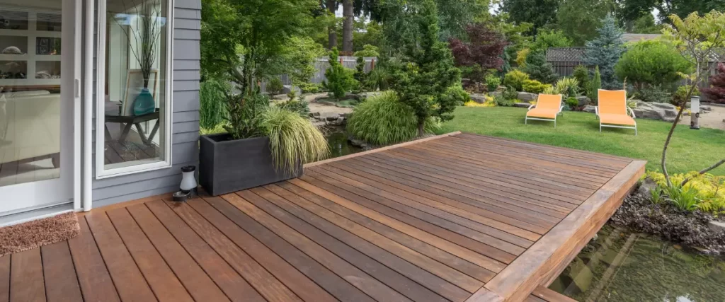 Floating wooden deck surrounded by lush backyard landscaping