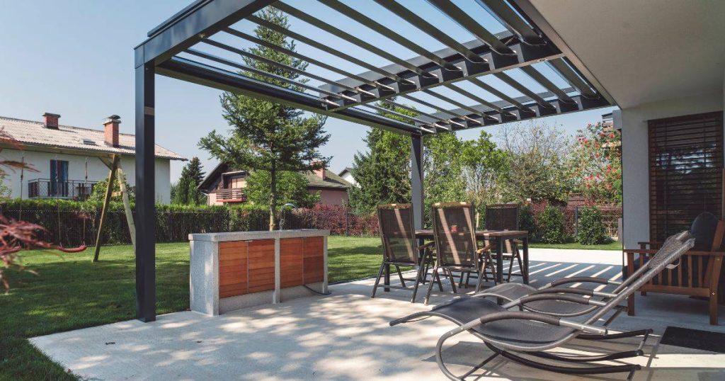Stylish patio with outdoor dining set under adjustable metal pergola