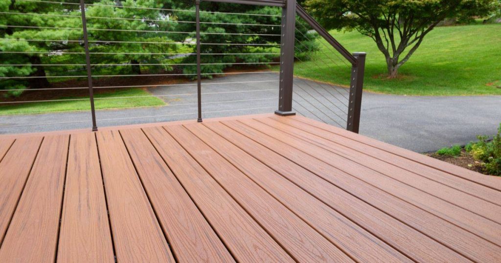 Composite deck with cable railing overlooking driveway and lawn