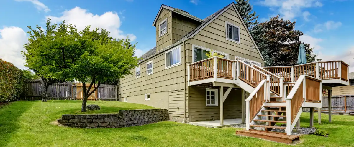 small house with a walkout wooden deck in the backyard