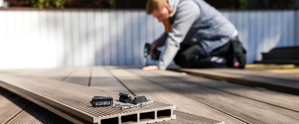 a handyman installing composite decking, a durable and low-maintenance alternative to traditional wood decking