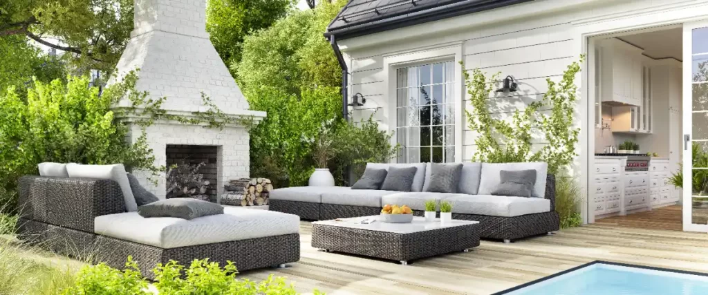 an outdoor patio furniture set with a sofa, chaise lounge, coffee table, and a fireplace