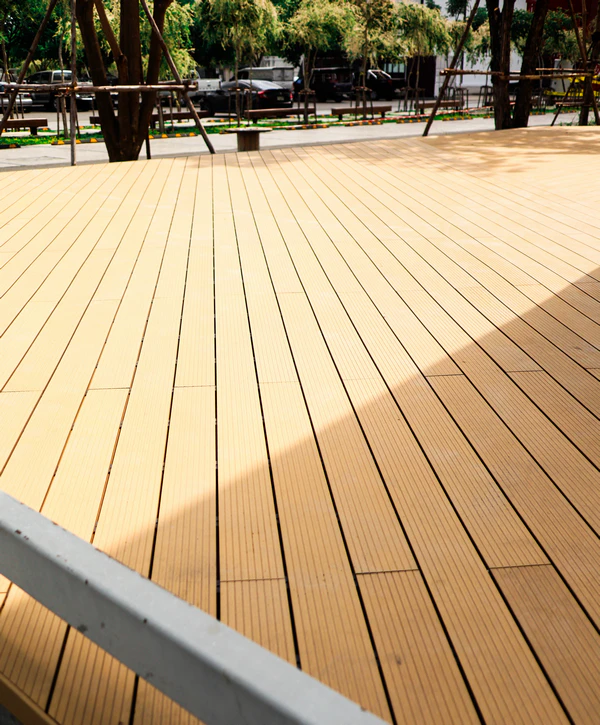 Close-up of high-quality composite deck building in Chattanooga, TN featuring light tan planks in a modern outdoor park setting.