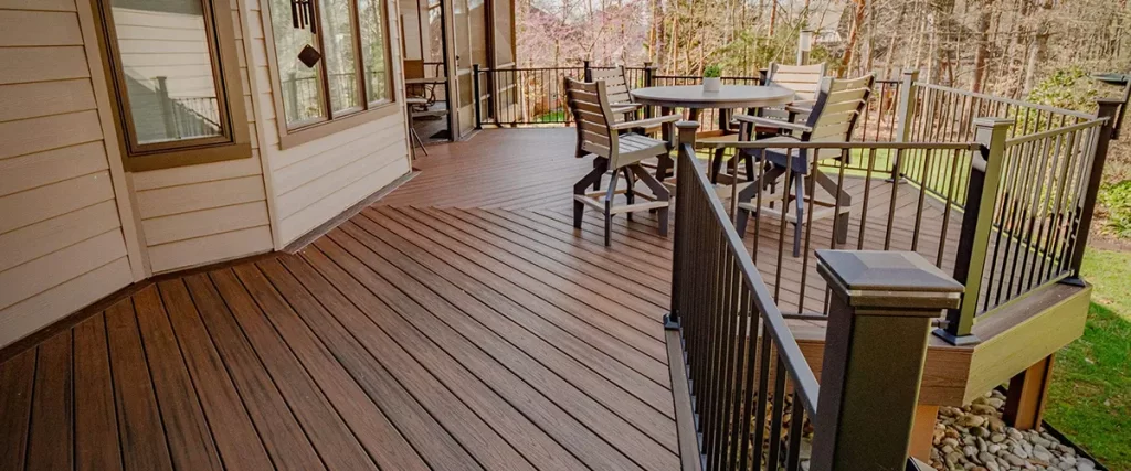 Composite deck addition with black aluminum railing and outdoor dining area overlooking backyard