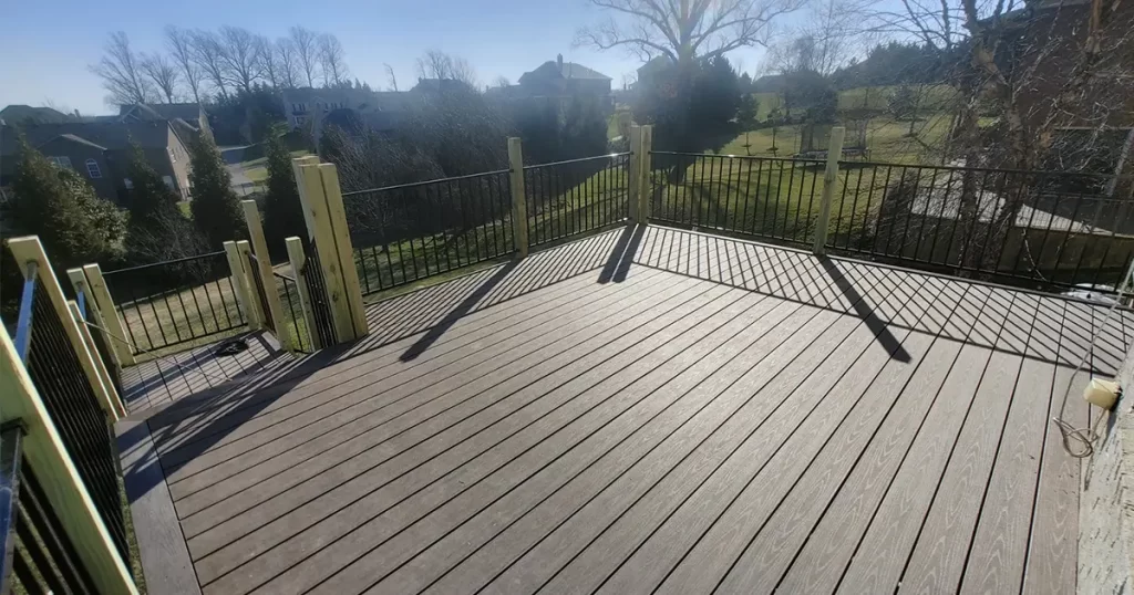 Large composite deck installation with black aluminum railing and spacious backyard view