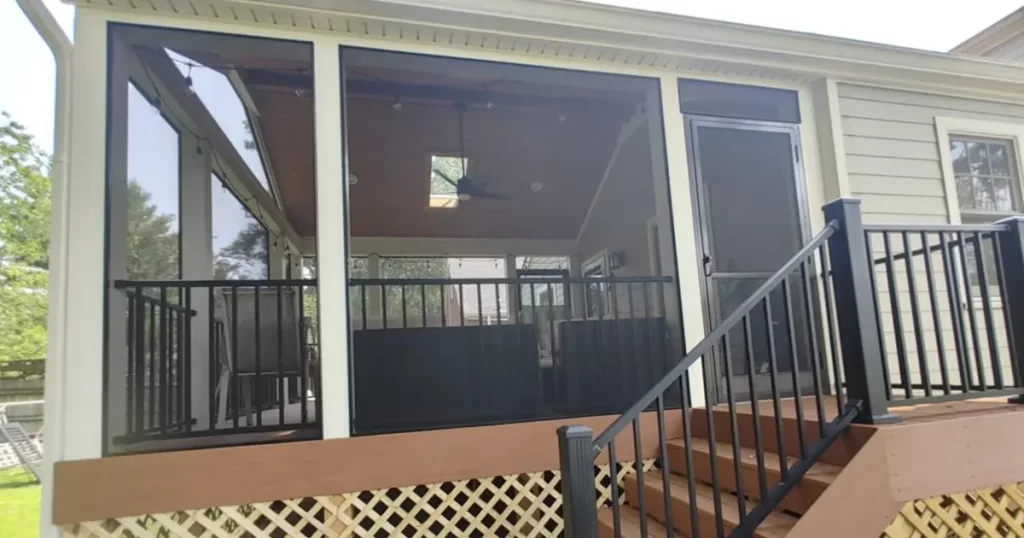 Screened porch addition with composite decking, black railing and covered outdoor living space